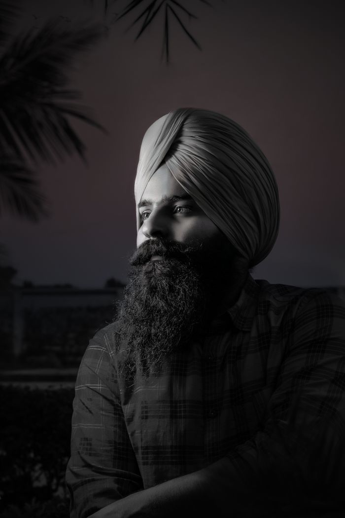 services-03 Dramatic black and white portrait of a man with a full beard and turban looking away.